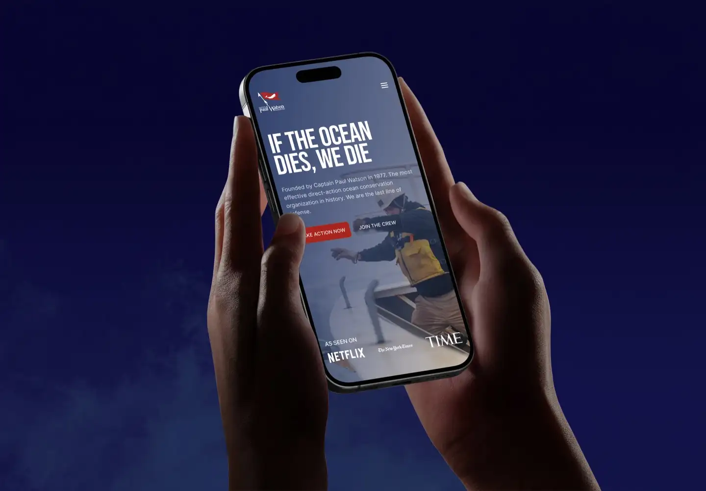 Phone held in both hands, showing the Captain Paul Watson Foundation site